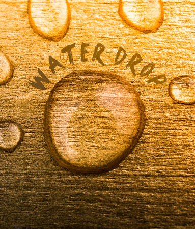 Water drop text and water drops on wooden surfaceの写真素材