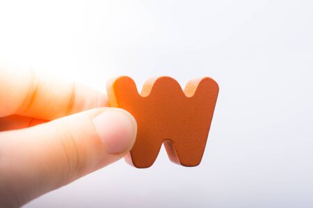 Hand holding letter cube W of made of woodの写真素材