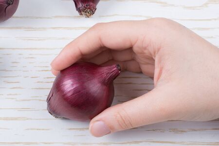 Whole red onion bulbs in brown on wooden backgroundの写真素材