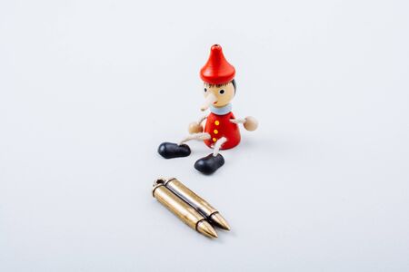 Bullet and wooden pinocchio doll with his long noseの写真素材