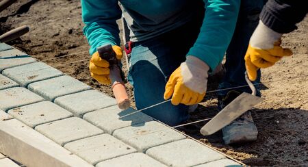 cobblestone installation - paver laying granite stone pavers using industrial cobblestonesの写真素材
