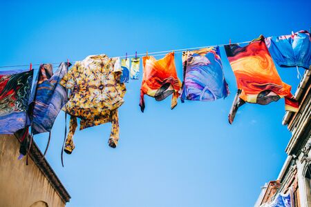 Clothes hanging from a clothes line rope in the streetの写真素材