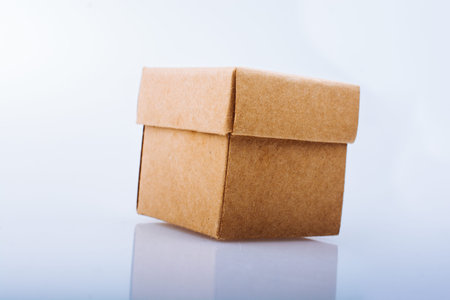 Hand holding a brown cardboard box on black backgrounds