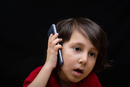 Little boy hold smartphone as modern mobile communication gadgetの写真素材