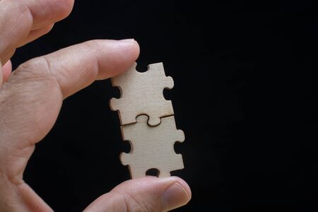 Man holding last piece of jigsaw puzzle as business strategy conceptの写真素材