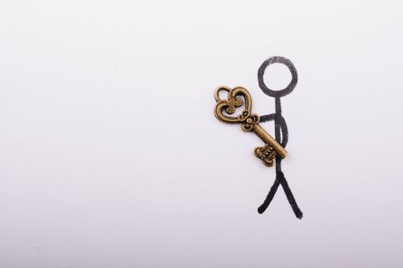 Man carrying a  heart shaped key  on white backgroundの写真素材