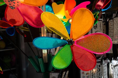 Rainbow colored pinwheels on sale in the viewの写真素材