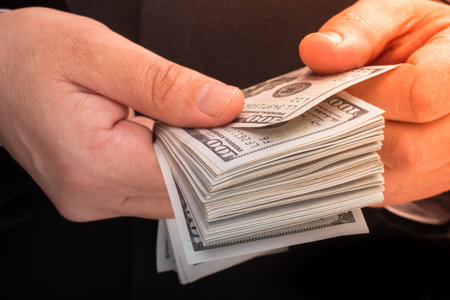 Businessman holding US dollar banknote money on white