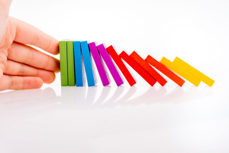 Hand holding color dominoes on a white background