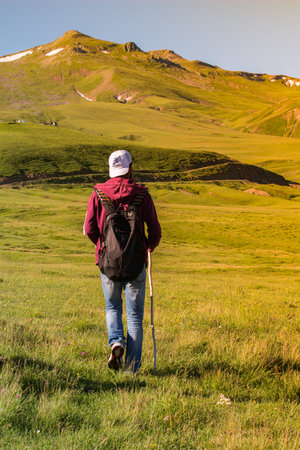 Hiker with backpacks and trekking poles walking in Turkish highland