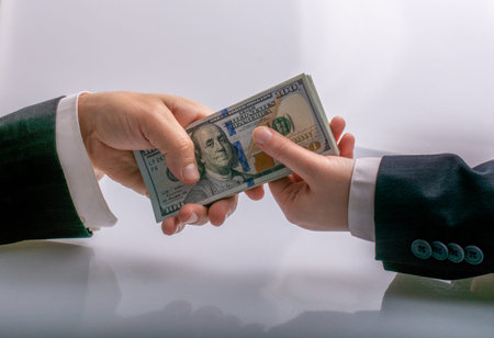 Businessman giving and receiving  US dollar banknote money