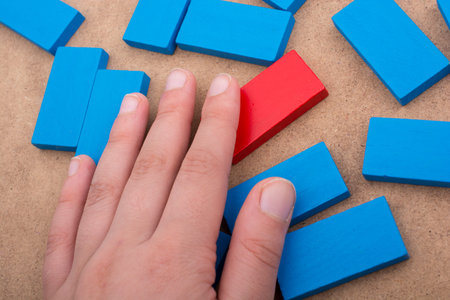 Hand holding one of the wooden blocks of various colors