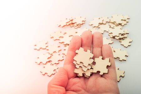 Hand holding piece of jigsaw puzzle as problem solution conceptの写真素材