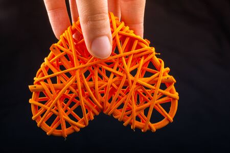Handmade straw heart or valentines day object in handの写真素材