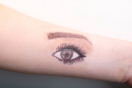 Single eye drawn on the arm of a teenagerの写真素材