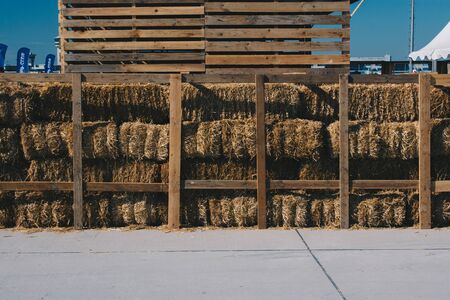 Harvesting in agriculture bales of hay are stacked in large stacksの写真素材