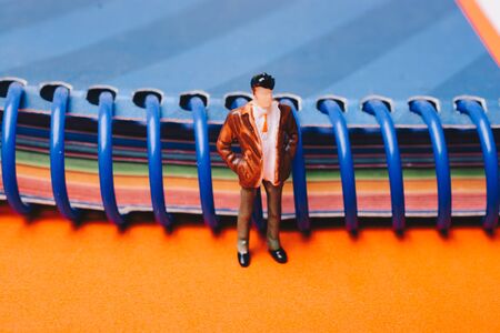 Figurine standing beside spiral notebookの写真素材
