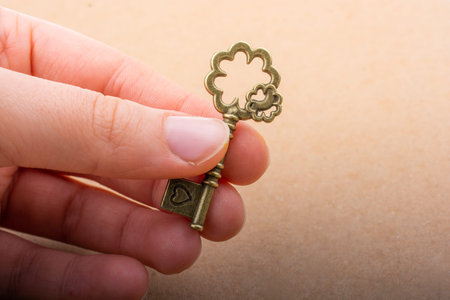 Hand holding a retro styled decorative key in handの写真素材