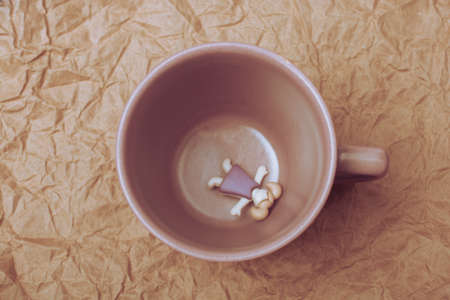 Miniature girl figurine lying at the bottom of mug cupの写真素材
