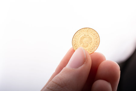 Turkish Ottoman style gold coin in hand on white background