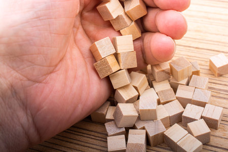 Hand playing with wooden cubes as  educational and business concept