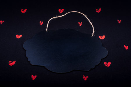 Black notice board  and red hearts on black background