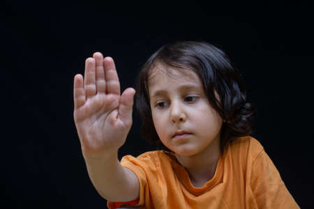 Boy showing stop gesture with his hand as prohibition  conceptの写真素材
