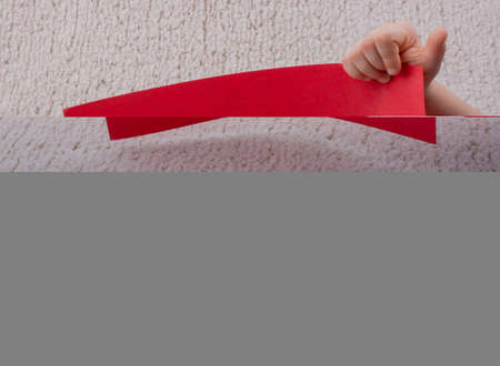 Little kid holding a red blank cardboard board in hands. Copy space for text.の写真素材