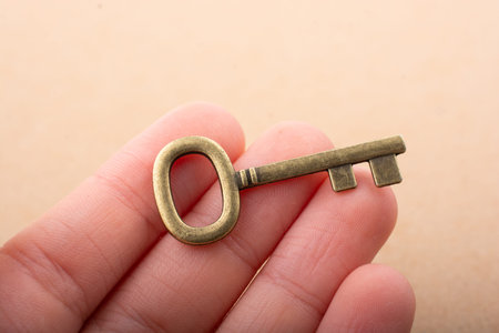 Hand holding a retro styled decorative key in hand