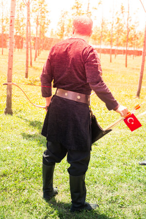 Archer with bow  in traditional clothes shooting an arrowの写真素材