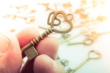 Hand holding retro metal key as love  and Valentine conceptの写真素材