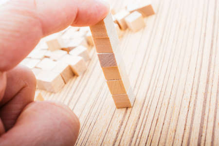 Hand playing with wooden cubes as  educational and business conceptの写真素材