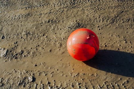 Colorful balloon on ground covered with mudの写真素材