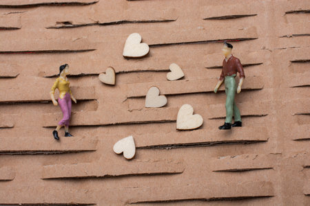 Tiny figurine of man  and woman miniature model and heart as love concept