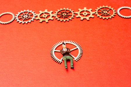 Little tiny man person figurine  and gear wheels as industry concept