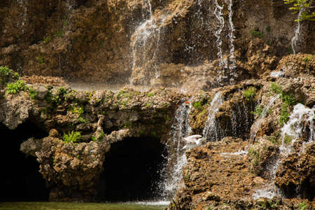 Small rocky waterfall pouring into a small poolの写真素材