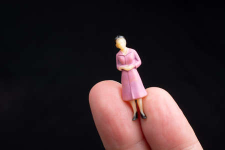 Figurine model women sitting on finger of handの写真素材