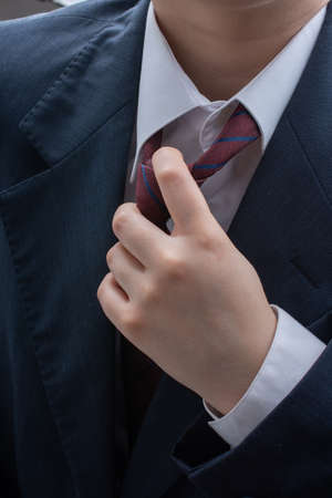 close up of a man fixing his tie knot. Fashion and elegance conceptの写真素材