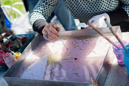 Hand drawing with stick stained inks on water surfaceの写真素材