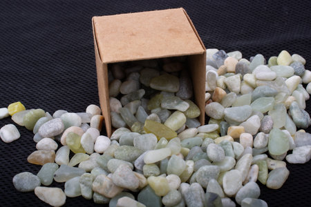 Stone pebbles gravels around brown cardboard box
