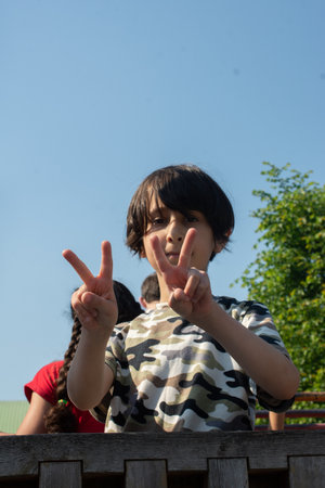 Portrait of little boy showing victory hand signの写真素材