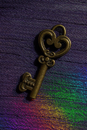 Vintage key. .Antique key. Retro key on colorful fabric background