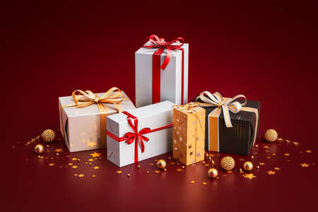 3d rendering of Christmas gifts or present boxes with decoration and xmas balls in front of red background and copy-space symbolizing shopping for web advertisingの写真素材