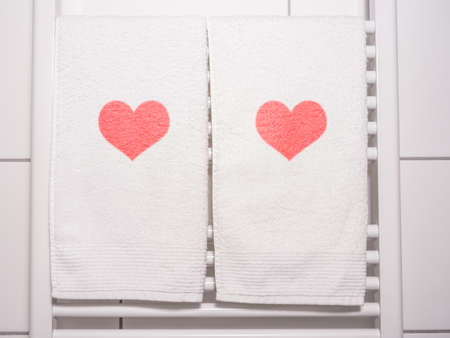 red hearts on towel on a heating in bathroomの写真素材