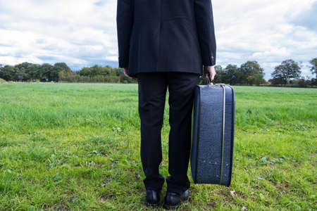 adult businessman holding a suitcase in landscapeの写真素材