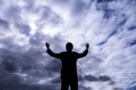 businessman in storm with lightning and rainの写真素材