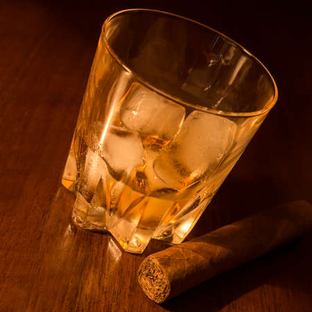 whiskey on ice and cigar on wood tableの写真素材