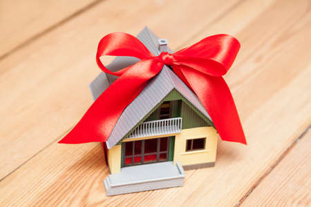 house with red ribbon on wooden floorの写真素材