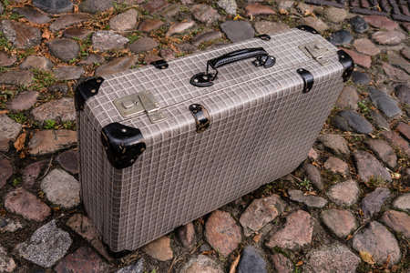 suitcase on cobble stone streetの写真素材