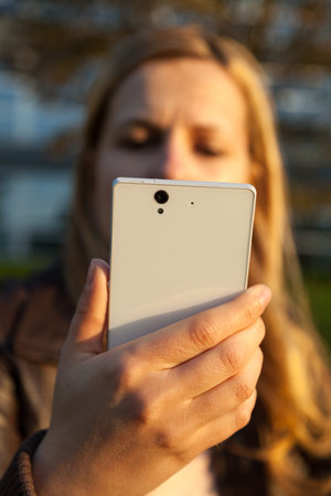 woman look at white smartphone in evening time
